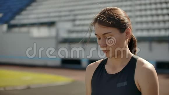 在体育场看台上奔跑的美女的慢动作肖像集中的深呼吸和激励视频的预览图