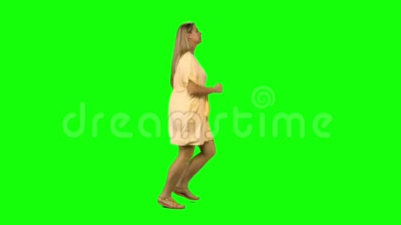 晒黑的金发女人在绿色的屏幕上微笑着奔跑侧写视图视频的预览图