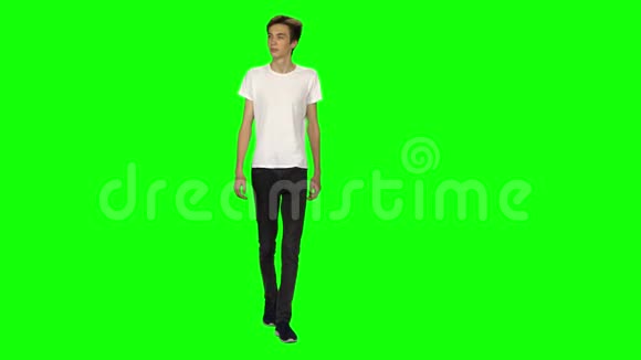 高大瘦小的年轻人平静地走在绿色屏幕背景上铬钥匙4k射击前景视频的预览图