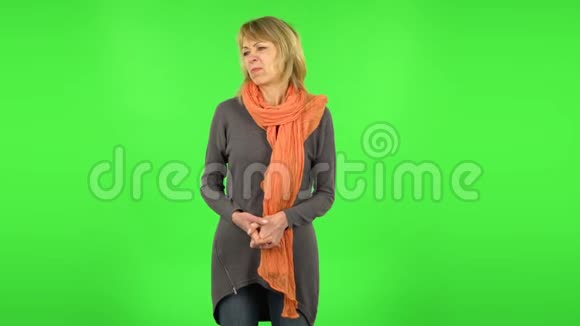 中年金发女人消极地挥舞着头绿色屏幕视频的预览图