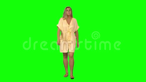 晒黑的金发女人平静地走着在绿色的屏幕上微笑铬钥匙4k射击前景视频的预览图