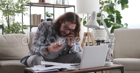 男人在家里的办公室里用手机说话视频的预览图