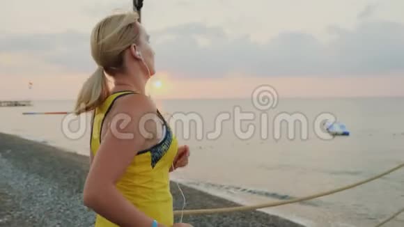 侧视图一名身穿运动服的年轻女孩在码头上晨跑迎接日出视频的预览图