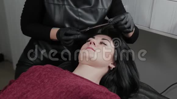 一位专业的永久性化妆大师用胶卷遮住客户的眉毛视频的预览图