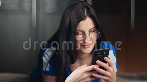 微笑的女人在家里使用智能手机有积极的情绪中型近距离拍摄4k红色相机视频的预览图