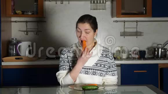 女孩坐在餐桌上吃胡萝卜视频的预览图