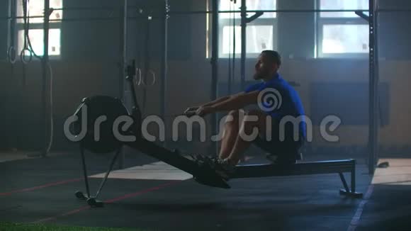 慢动作一个人在阳光下的大气健身室里划船劳尔火车有氧运动运动员视频的预览图