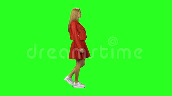 金发女孩平静地走在绿色的屏幕背景上铬钥匙4k射击侧写视图视频的预览图