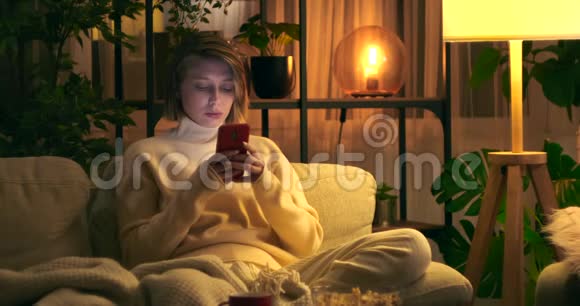 女人用手机晚上喝咖啡视频的预览图