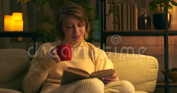 女人晚上在沙发上喝咖啡看书视频的预览图