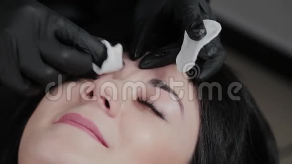 专业的永久化妆师用棉垫从脸上卸妆给客户视频的预览图