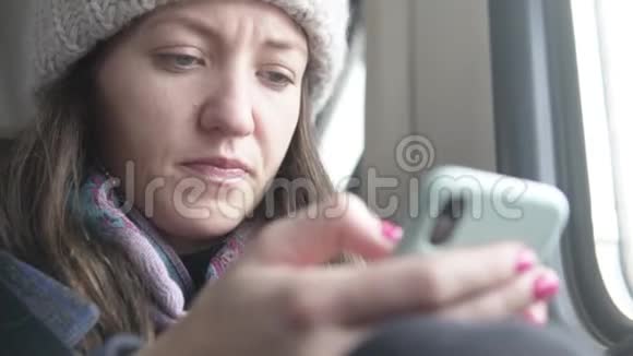 女人在火车上用手机拨信息视频的预览图
