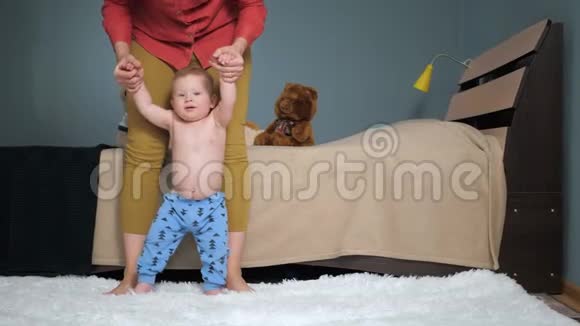 妈妈牵着宝宝的手向前看镜头第一个婴儿台阶概念慢动作视频的预览图