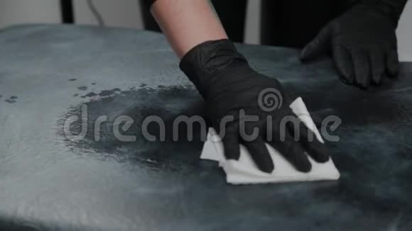 专业的永久化妆师用防腐剂擦拭沙发视频的预览图