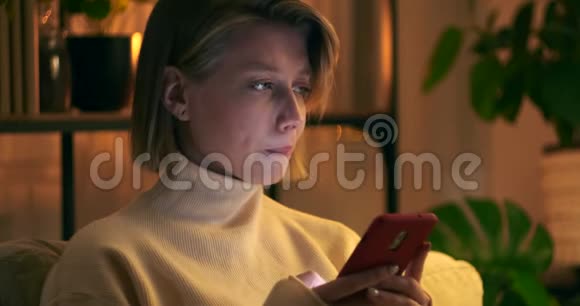 晚上在沙发上用手机聊天的女人视频的预览图