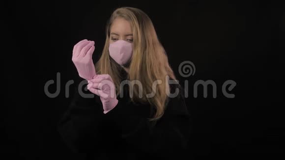 穿着粉红色医疗面具的女孩在手上伸直了粉红色的手套孤立在黑色背景上保健和医疗概念视频的预览图