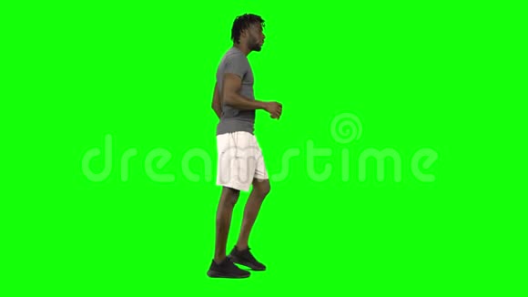 非裔美国人在绿色屏幕上散步和喝咖啡ChromaKey侧写视图视频的预览图