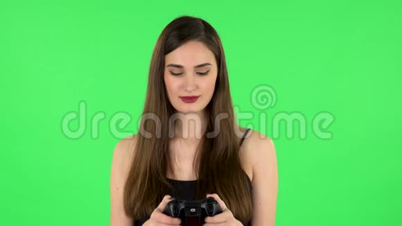 女孩玩电子游戏使用无线控制器绿色屏幕视频的预览图