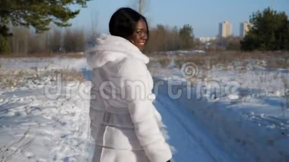 快乐的黑人妇女走在冬天森林的雪道上视频的预览图