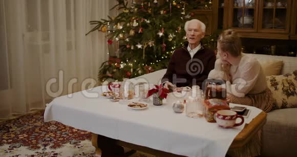 圣诞节在家听爷爷讲话的女人视频的预览图