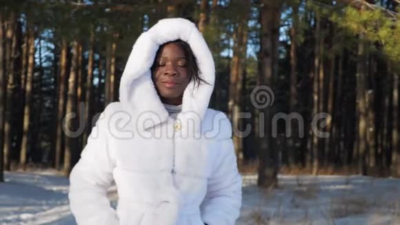 美国黑人女孩在冬季公园的树上摆姿势视频的预览图