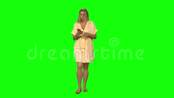 晒黑的金发女人正平静地走着在手机上说话绿色的屏幕上带着微笑前景视频的预览图