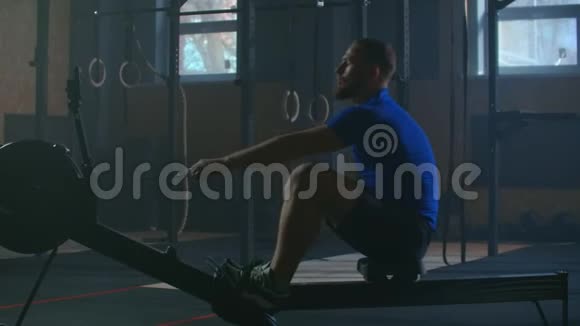 慢动作一个人在阳光下的大气健身室里划船火车视频的预览图