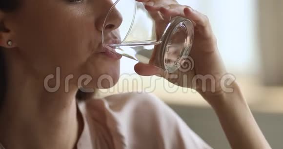口渴的脱水妇女拿着玻璃饮用水近距离观看视频的预览图