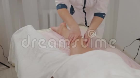 女按摩师在一个年轻女孩的小腿肌肉上做按摩视频的预览图