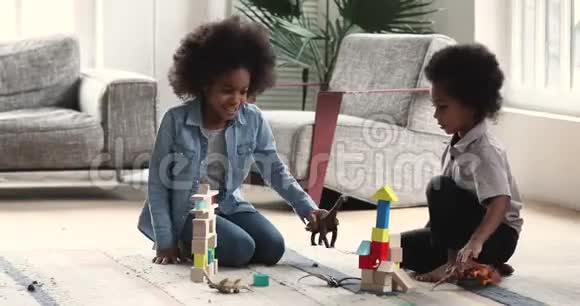 快乐的非洲孩子玩玩具坐在家里的地板上视频的预览图