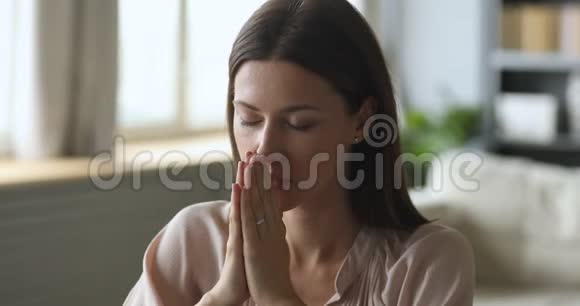 基督徒年轻女子在家闭着眼睛祷告视频的预览图
