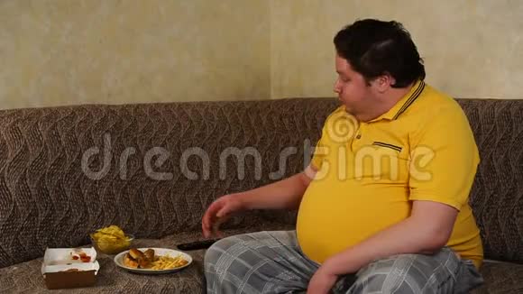 坐在家里看电视吃快餐的胖子视频的预览图
