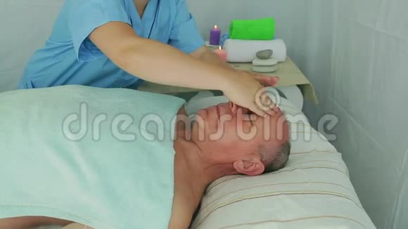 女性美容师在水疗沙龙为客户提供面部美容按摩视频的预览图
