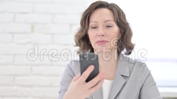 老女人用智能手机说话视频的预览图