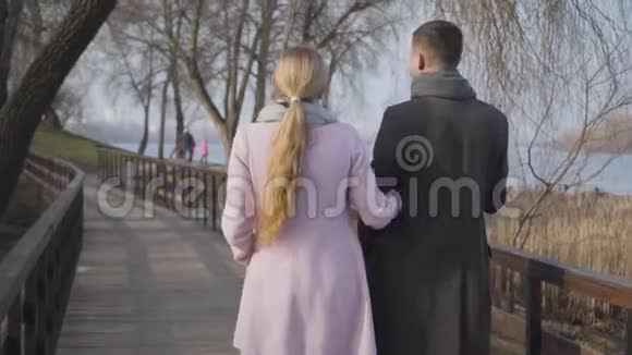 在公园散步的穿着优雅外套的成年白种人男女的后景积极的已婚夫妇享受阳光视频的预览图