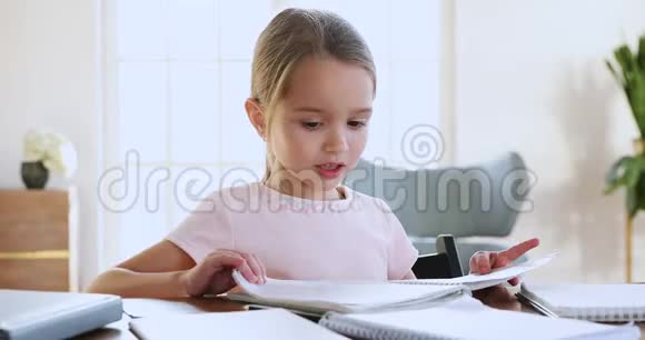可爱的女学生拿着作业本检查作业坐在书桌上视频的预览图