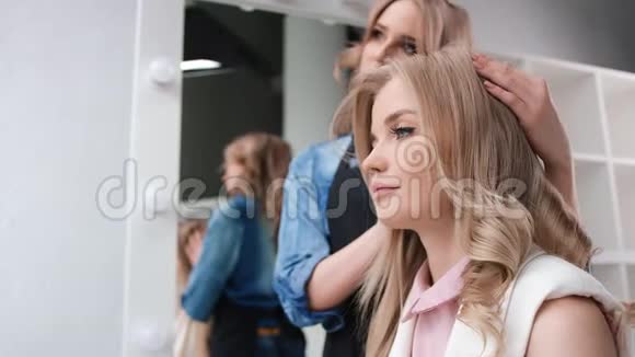 专业发型师整理造型发型少女客户中型摄影机视频的预览图