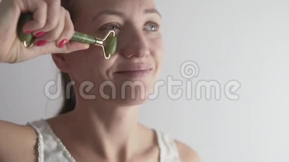 一个女人用一种特殊的眼睑滚轮按摩面部以对抗皱纹视频的预览图