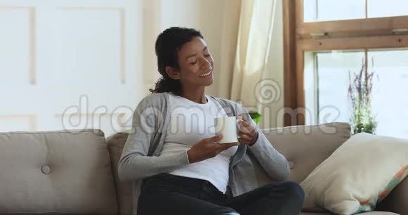 快乐平静的双种族女孩喝咖啡享受周末休闲时间视频的预览图