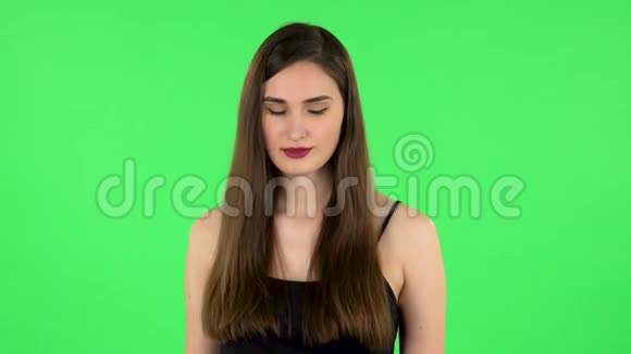 女孩画着她的嘴唇看着红色的镜子绿色屏幕视频的预览图