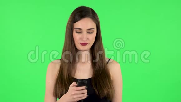 手里拿着电视遥控器的女人打开电视笑得很厉害绿色屏幕绿色屏幕视频的预览图