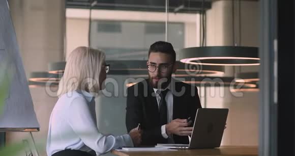 微笑年轻男性阿拉伯理财顾问咨询中年女商人视频的预览图