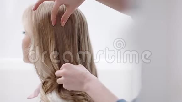 理发师女性最后触摸整理卷发金发近距离拍摄4k红色相机视频的预览图