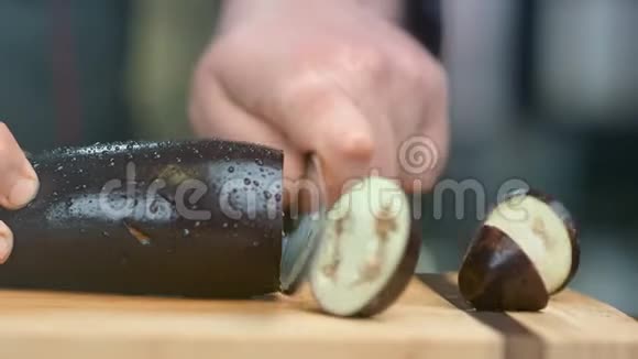 专业厨师用刀在木板上切茄子近距离拍摄4k红色相机视频的预览图