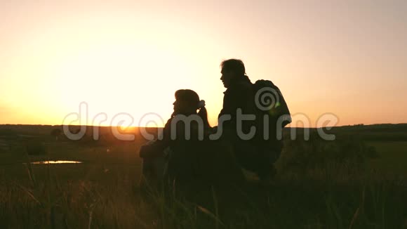 游客带着背包男人和女人看日落自由旅行者在山顶上休息享受日落视频的预览图