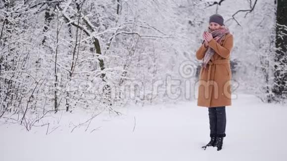 一个女人在冬天的森林里喝热茶视频的预览图