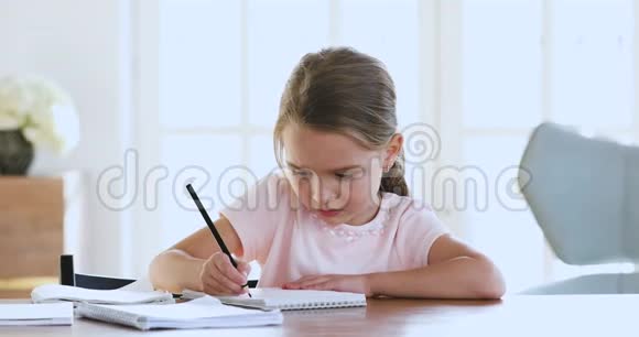 可爱的聪明的学校孩子女孩学习写作做数学作业视频的预览图