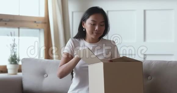 令人兴奋的亚洲女性消费者打开包裹箱接收装运订单视频的预览图