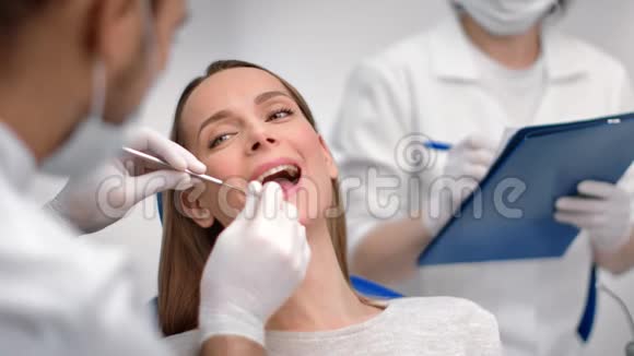 在口腔科的牙科检查中张开嘴面对微笑的女人近距离拍摄4k红色相机视频的预览图