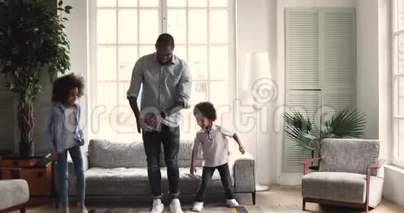 有趣的非洲儿童与父亲跳舞客厅内部视频的预览图